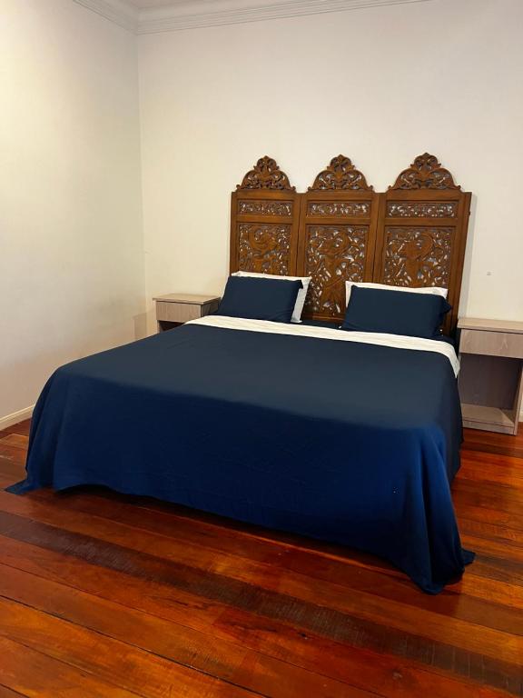 a bedroom with a blue bed with blue sheets and wooden floors at LUMUN Holiday Home Rental in Penampang