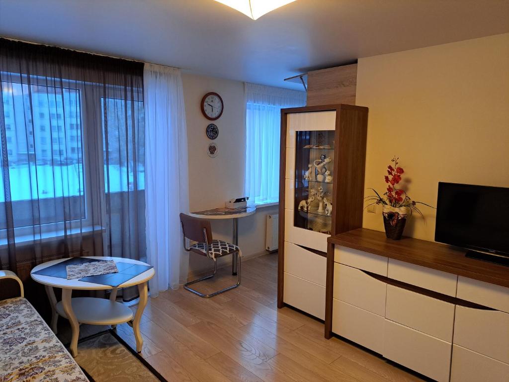 un soggiorno con cucina e una camera con tavolo di Lubānas apartamenti a Rēzekne