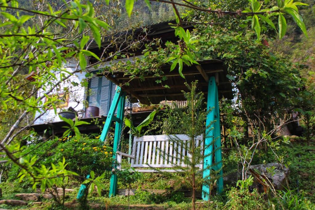 dom z ławką i niebieską migawką w obiekcie Chapi Dreamy Home w mieście Sa Pa