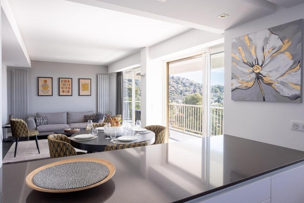 uma sala de estar com uma mesa e um sofá em Cannes Panorama - Piscine, vue mer, parking, clim em Cannes