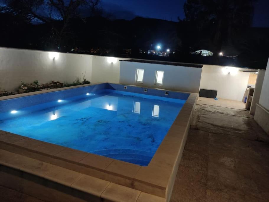 a large swimming pool in a backyard at night at Alojamiento entero: chalet. in Alicante