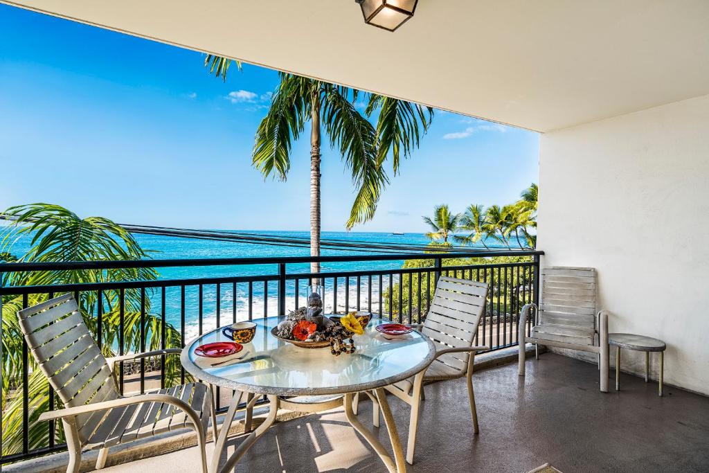 a table and chairs on a balcony with a view of the ocean at Kona Alii 201 in Kailua-Kona