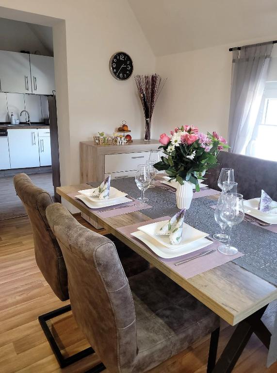 a dining room table with chairs and flowers on it at Ferienwohnung Classen Eifel in Schleiden