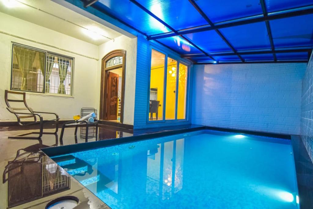 a swimming pool in a house with a blue ceiling at Dev1villa in Lonavala