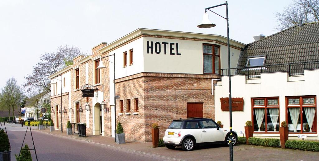 une voiture blanche garée devant un hôtel dans l'établissement Hotel Huys van Heusden, à Asten