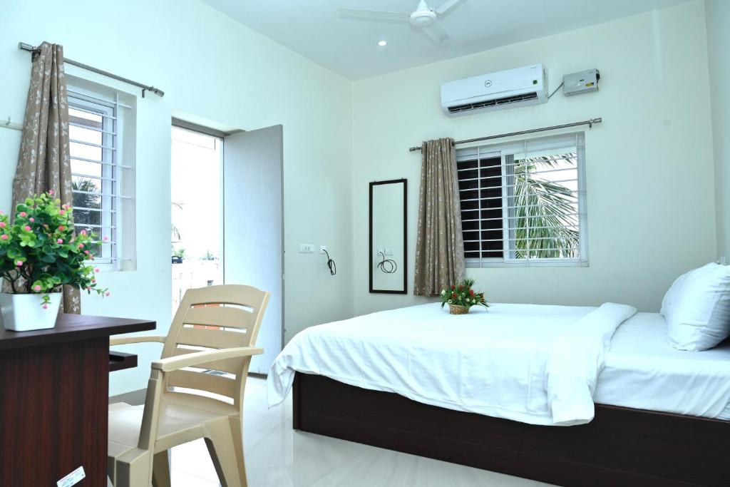 a bedroom with a bed and a desk and a chair at VINNEST in Tiruchchirāppalli