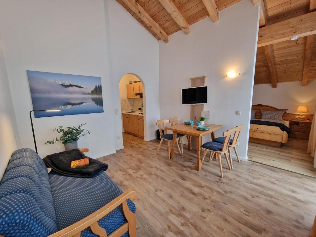 a living room with a blue couch and a table at HoFer am Zeitberg Ferienwohnung Falleralm in Bad Kohlgrub