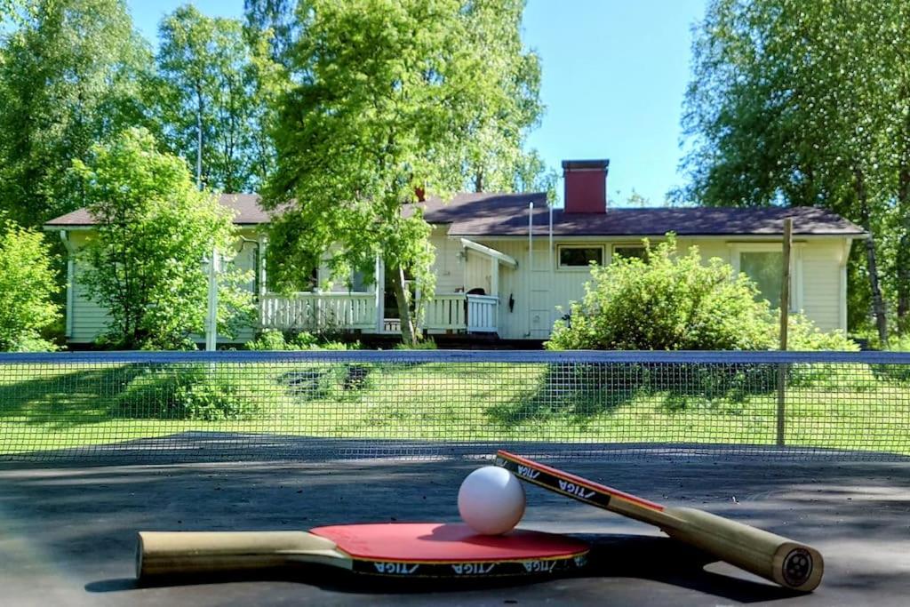 einen Tennisplatz mit einem Ball und einem Schläger in der Unterkunft Cozy Summerhouse by the River in Rovaniemi