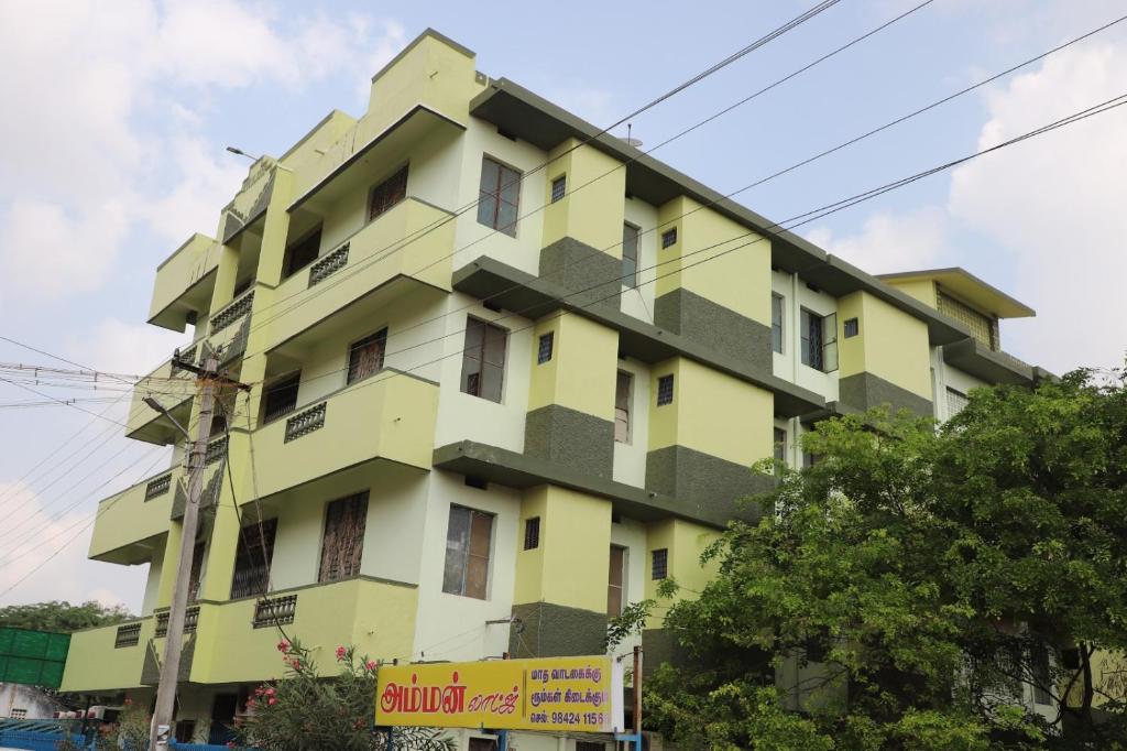 ein gelbes Gebäude mit vielen Fenstern in der Unterkunft AMMAN LODGE in Tiruchchirāppalli