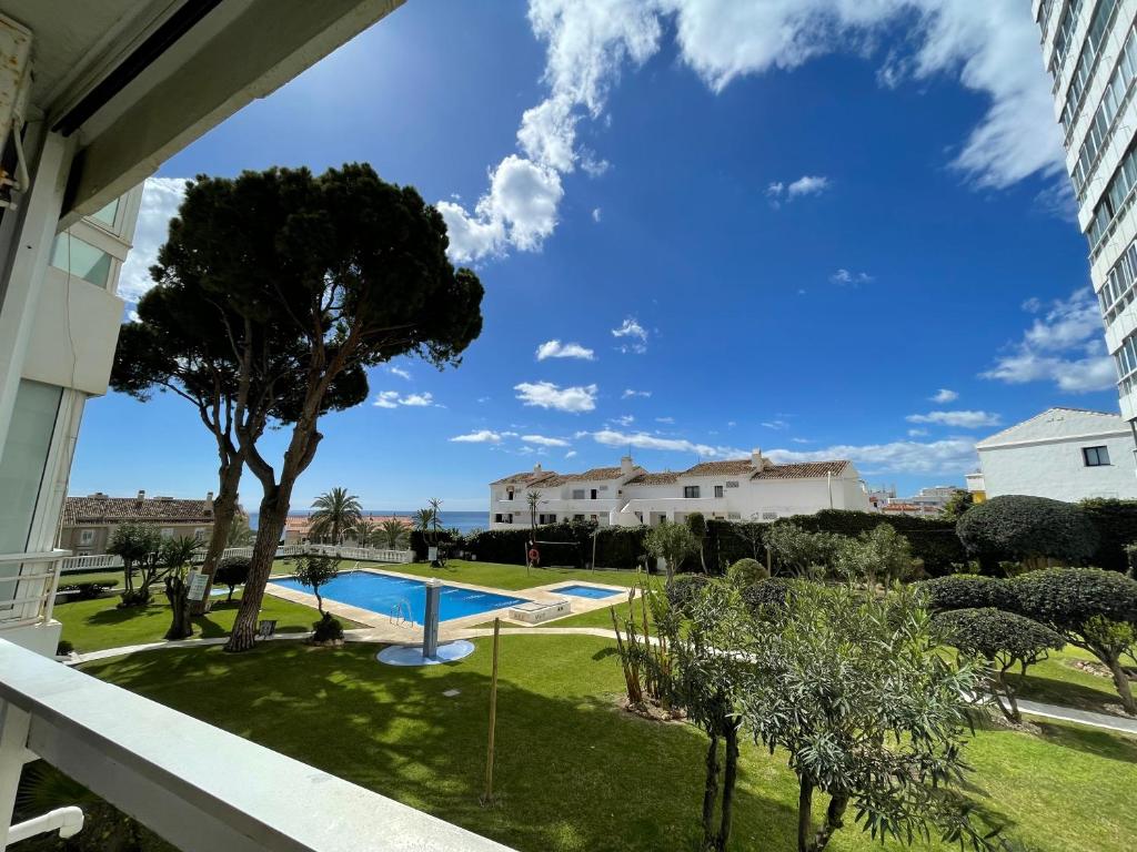 ベナルマデナにあるApartamento Los Cisnesのプールの景色を望むバルコニーが備わるアパートメントです。