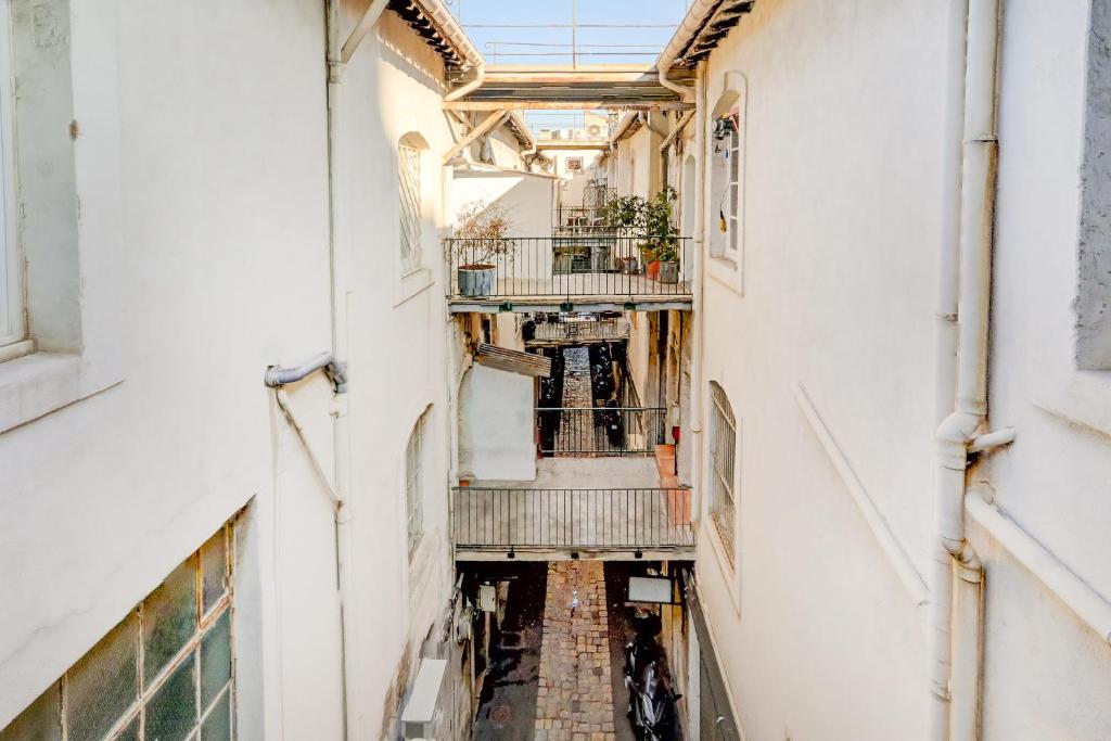un couloir vide d'un immeuble avec des escaliers et une fenêtre dans l'établissement LOFT D'ARCHITECTE SUR LE VIEUX PORT, à Marseille