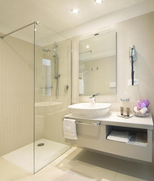 een badkamer met een wastafel en een glazen douche bij Seven Park Hotel Lake Como - Adults Only in Colico