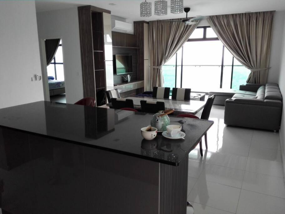 a kitchen and living room with a black counter top at Skyloft Premium Suites 8 pax in Johor Bahru