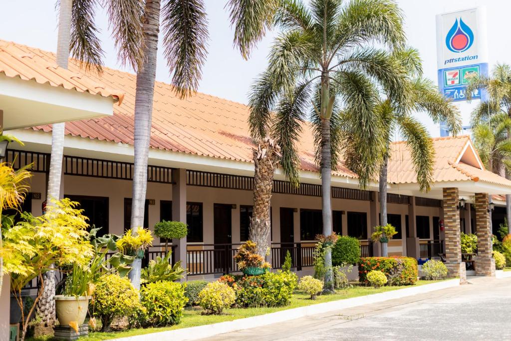 a front view of a hotel with palm trees at โรงแรมมณีสังขะ in Sangkha