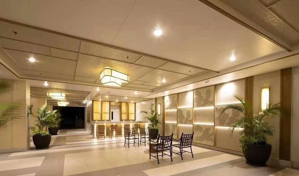 a lobby with chairs and a table in a building at Modern Living by The Celandine DMCI in Balintawak in Manila