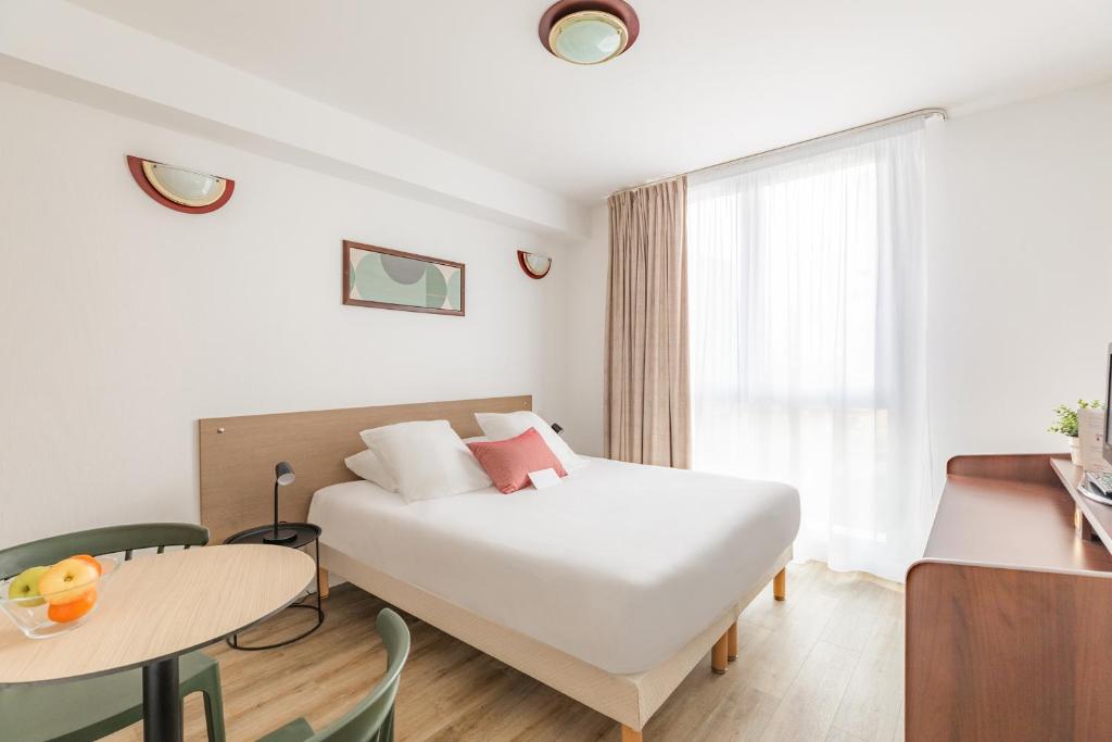 Habitación de hotel con cama, mesa y ventana en Appart'City Confort Brest en Brest