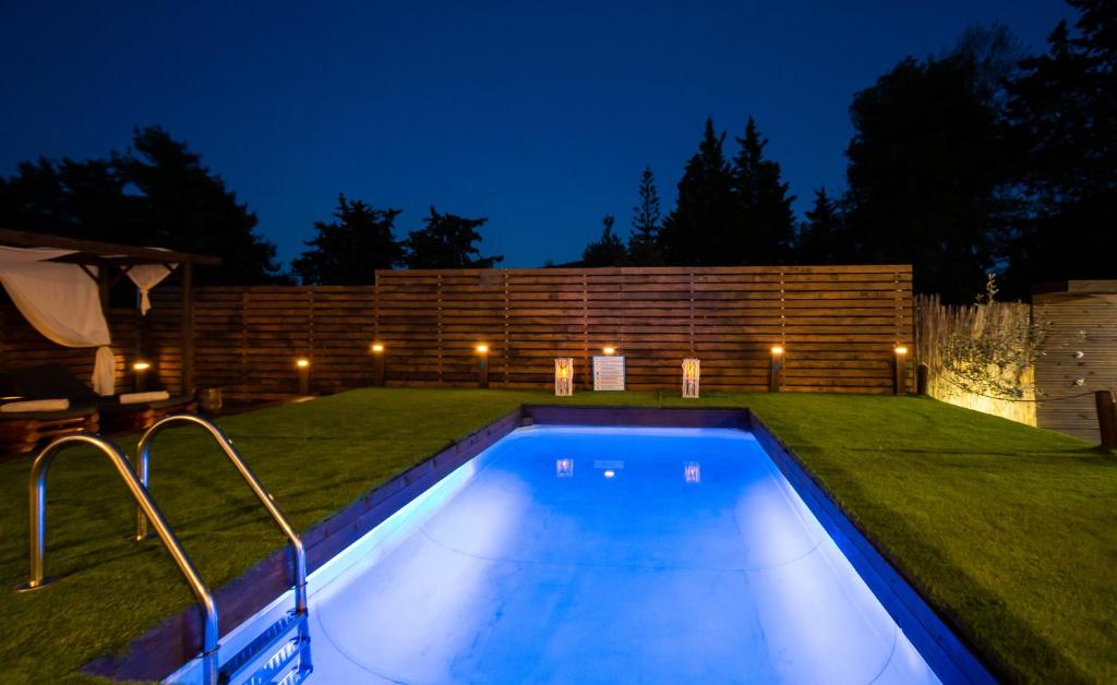 a swimming pool in the middle of a yard at night at Villa Paulanelas in Gaïtánion