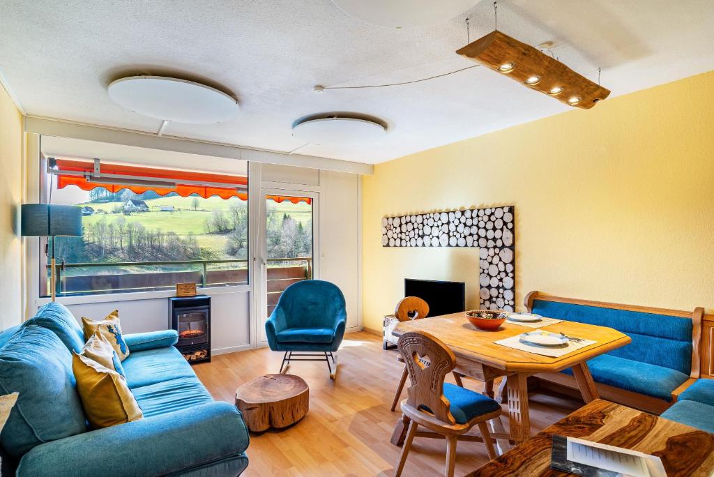 a living room with a blue couch and a table at Schwarzwald Wölkchen in Baiersbronn