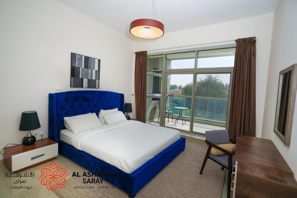 a bedroom with a bed and a desk and a window at Alashrafia Saray 2BR apartment in Sport City in Dubai