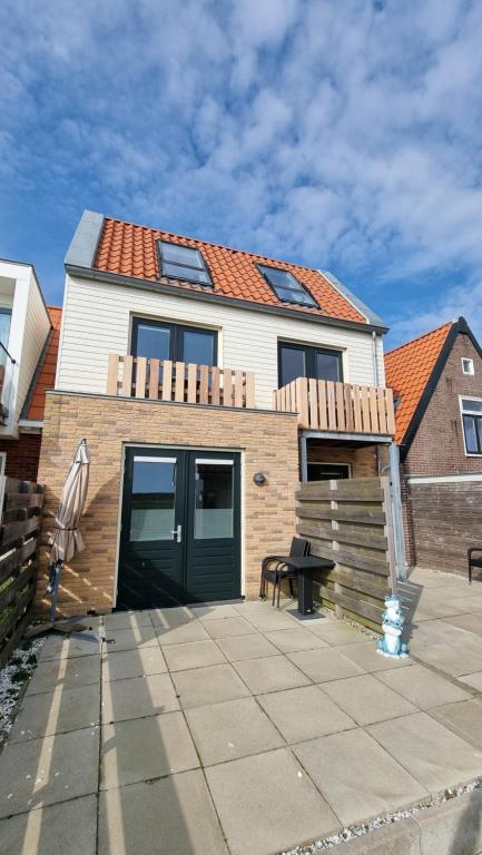 une maison avec une porte verte et une terrasse dans l'établissement Ut Endt Vlieland, à Oost-Vlieland