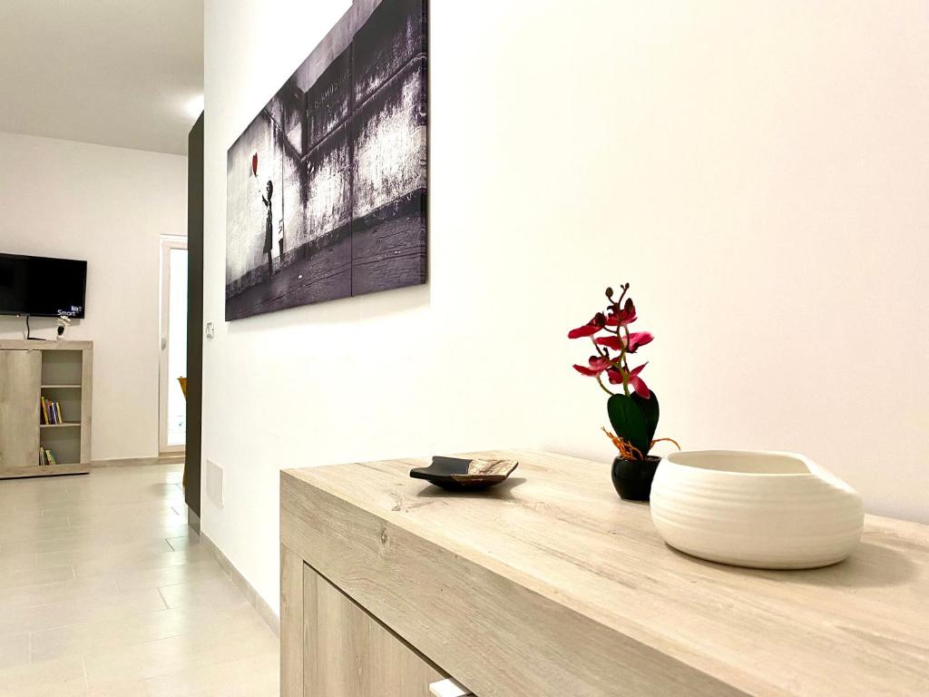 ein Wohnzimmer mit einem Tisch und einer Vase darauf in der Unterkunft Monopoli Sky House - Puglia Mia Apartments in Monopoli