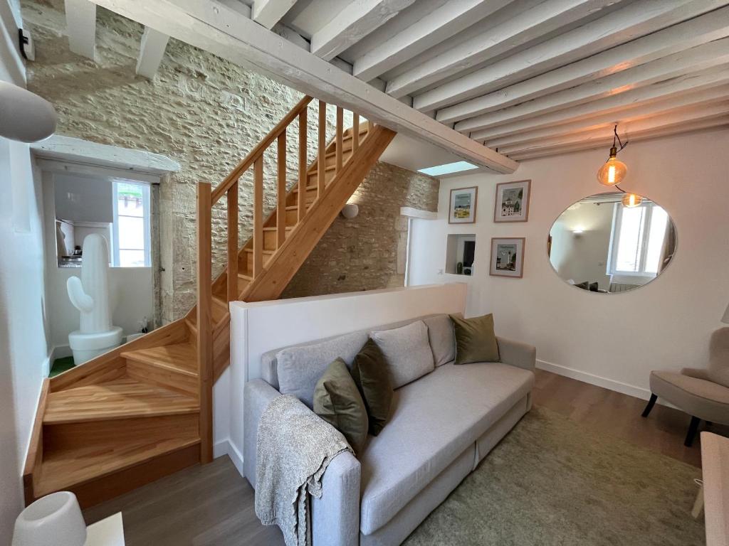 - un salon avec un canapé et un escalier dans l'établissement Bella YourHostHelper, à Ouistreham