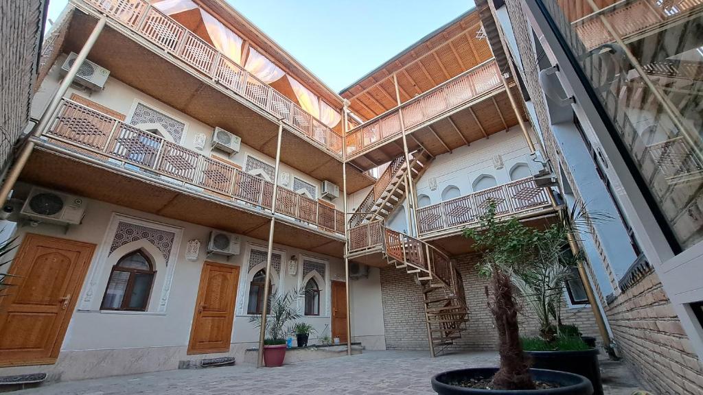 a building with a spiral staircase in a courtyard at Naqshband in Bukhara