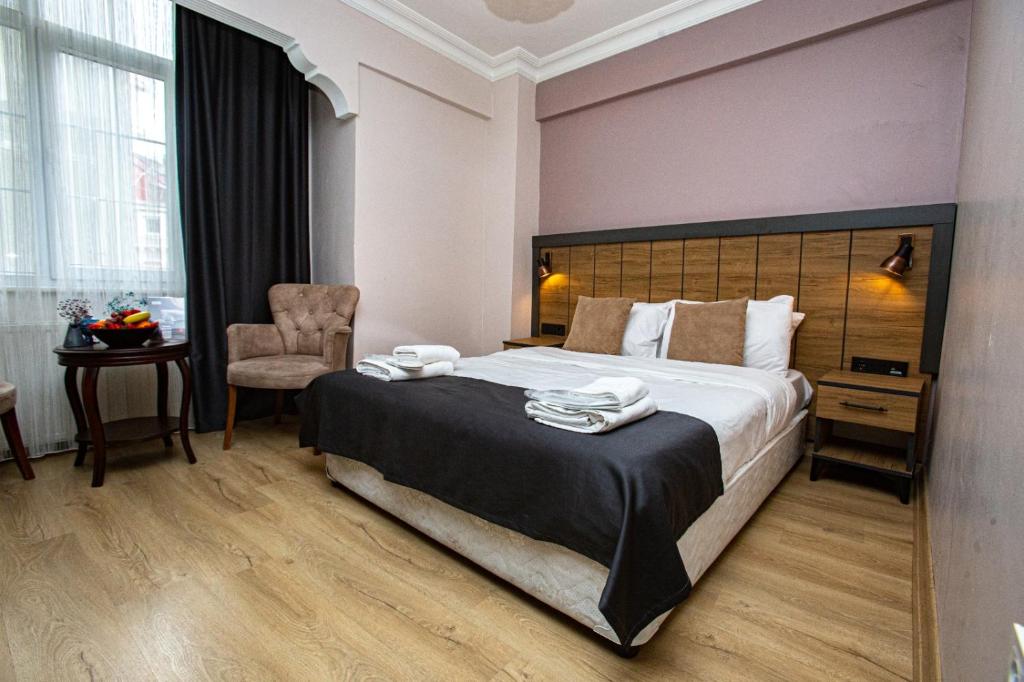 een hotelkamer met een groot bed en een stoel bij Comfort Hotel Taksim in Istanbul