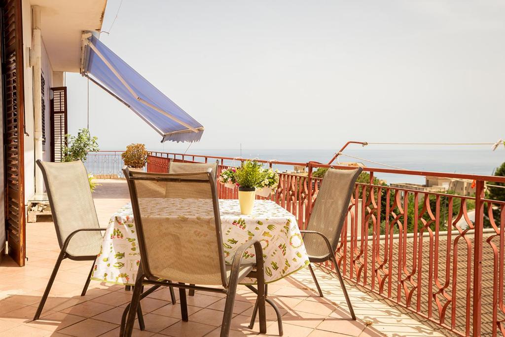 einen Tisch und Stühle auf einem Balkon mit Meerblick in der Unterkunft Da Jaco in Castellammare del Golfo