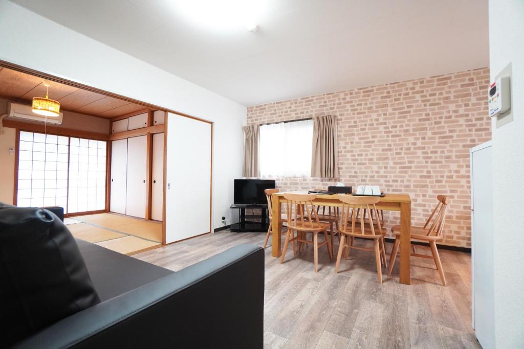 een keuken en een woonkamer met een tafel en stoelen bij Miyabi Stay Yuhigaoka in Osaka