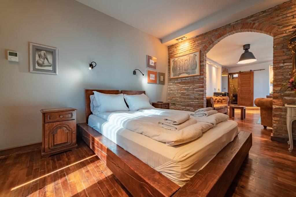 a bedroom with a large bed with a wooden frame at Le Rendezvous Apartments New Town in Veliko Tŭrnovo