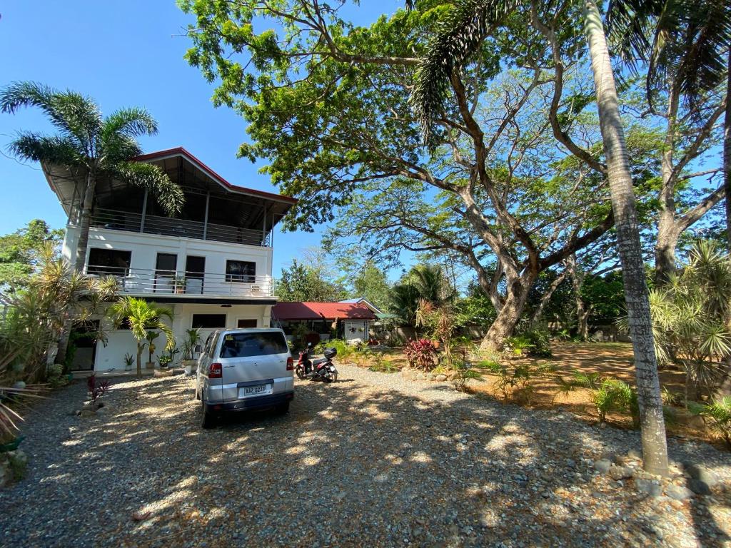 a car parked in front of a house at La Vida Hostel in Puerto Princesa City