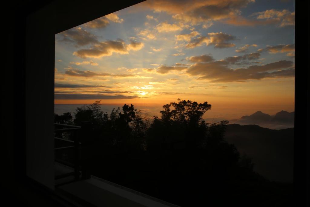 a view of a sunset from a window at Alishan B&amp;B YunMinGi in Fenqihu