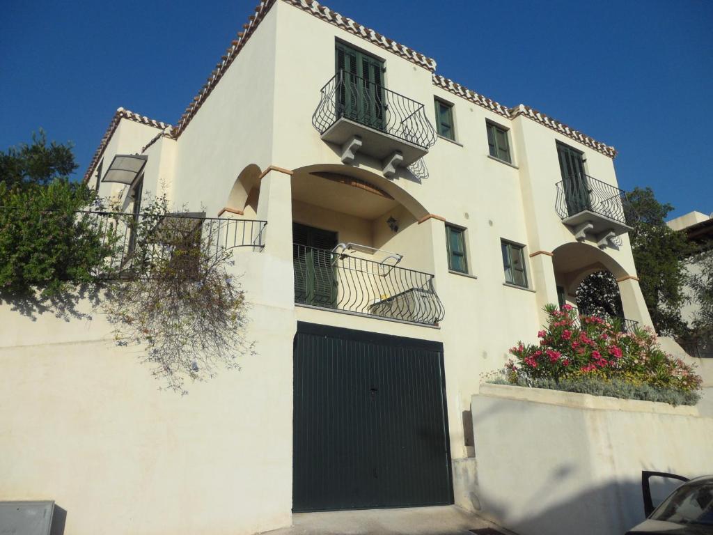 a white building with a black door and a balcony at Casa Vacanza Arbatax in Àrbatax