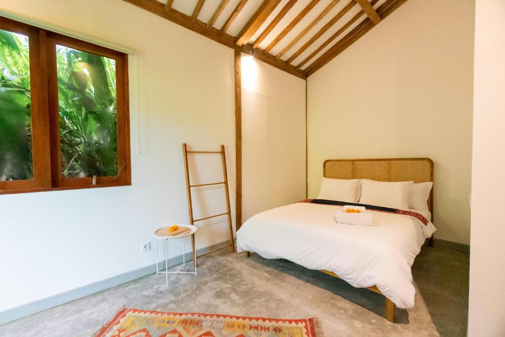 sypialnia z łóżkiem i oknem w obiekcie Singgah di Ubud 2 w mieście Ubud