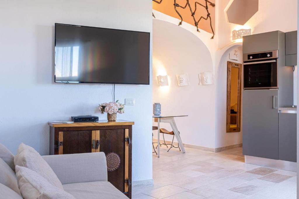 Una sala de estar con un sofá y un televisor en la pared. en Casa di Design nel cuore della Costa Smeralda, en Arzachena