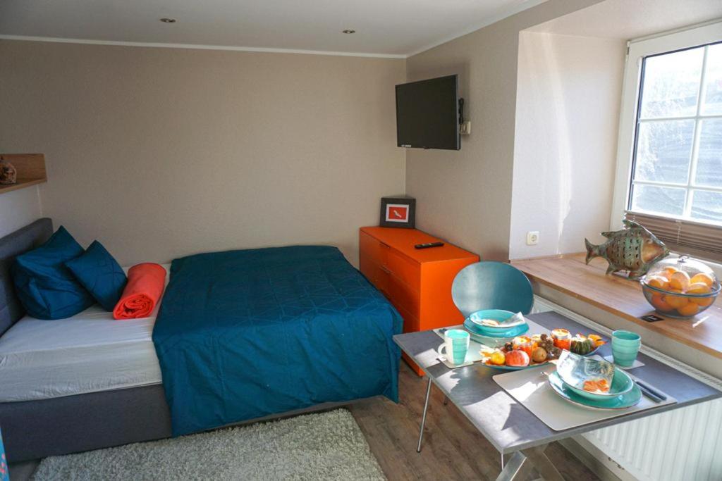 um quarto com uma cama e uma mesa com uma bandeja de frutas em Burghaus 2 em Greetsiel
