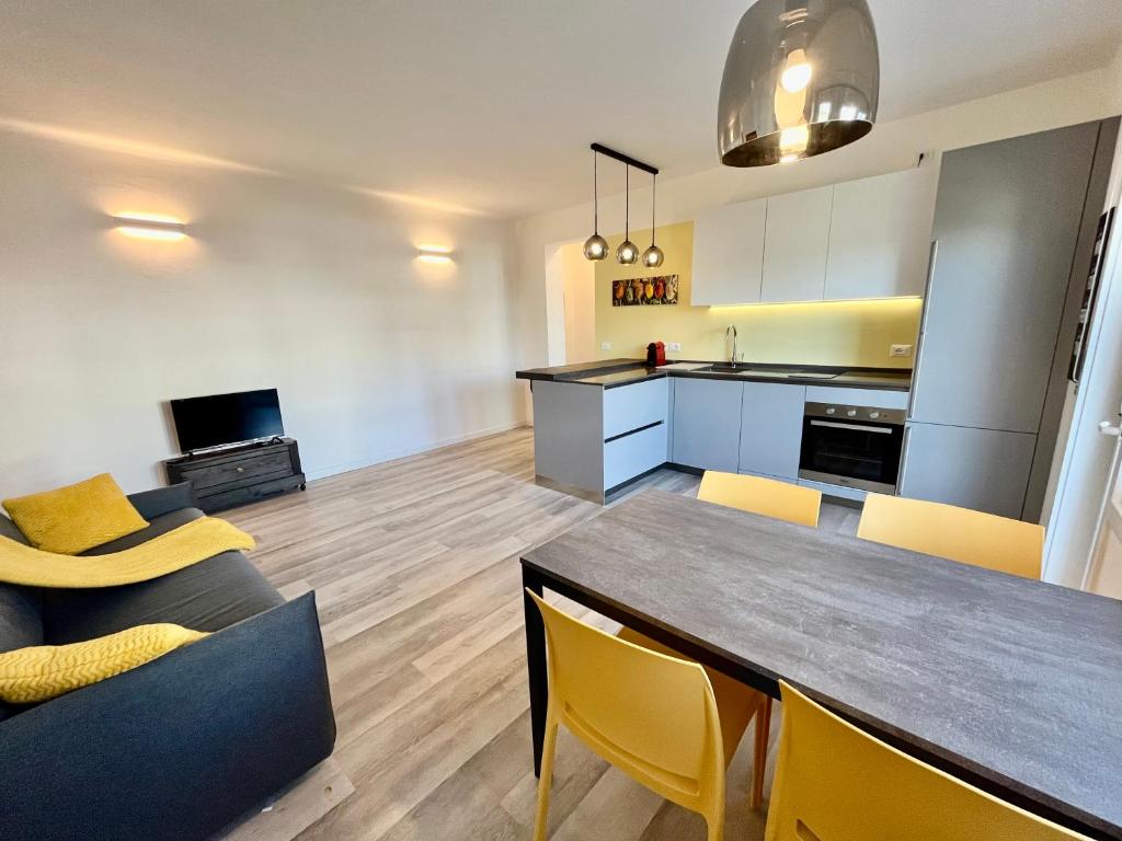 a kitchen and living room with a table and chairs at Condominio Martini in Grado