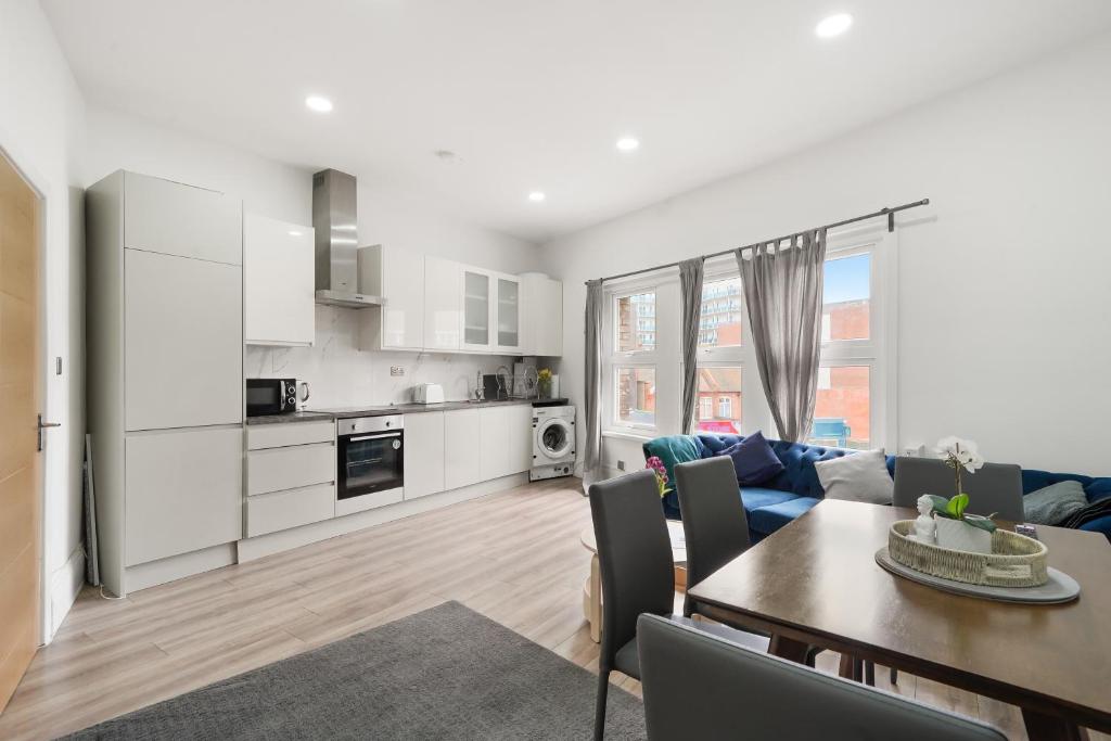 uma cozinha e sala de estar com uma mesa e um sofá em 3BR Duplex Penthouse Harrow centre em Harrow