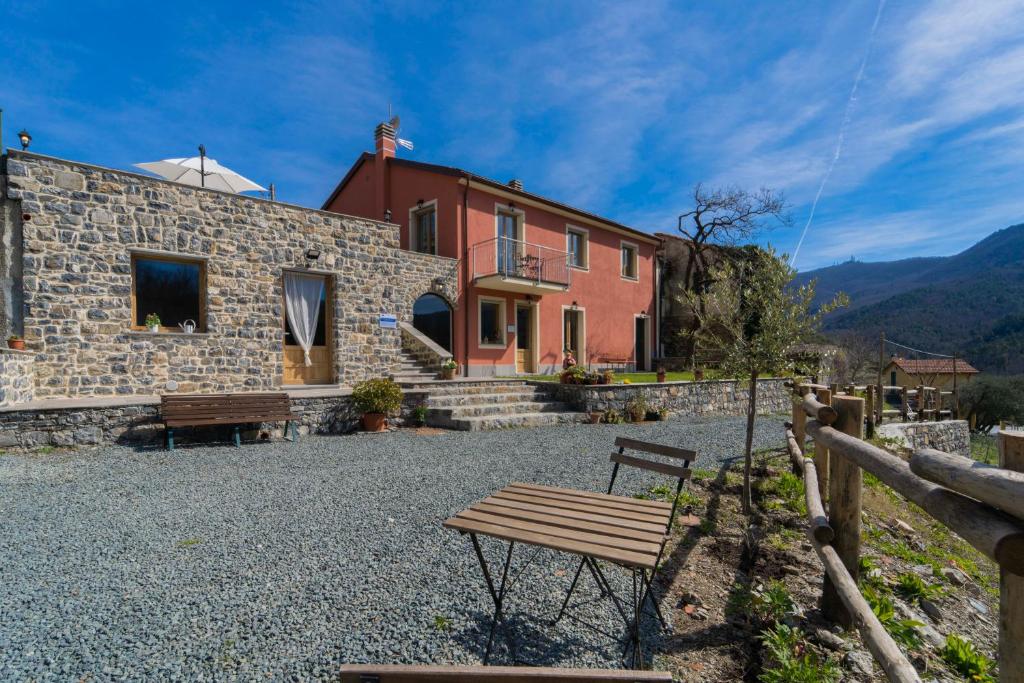 una casa in pietra con una panchina davanti di Agriturismo Torsivì a Castiglione Chiavarese