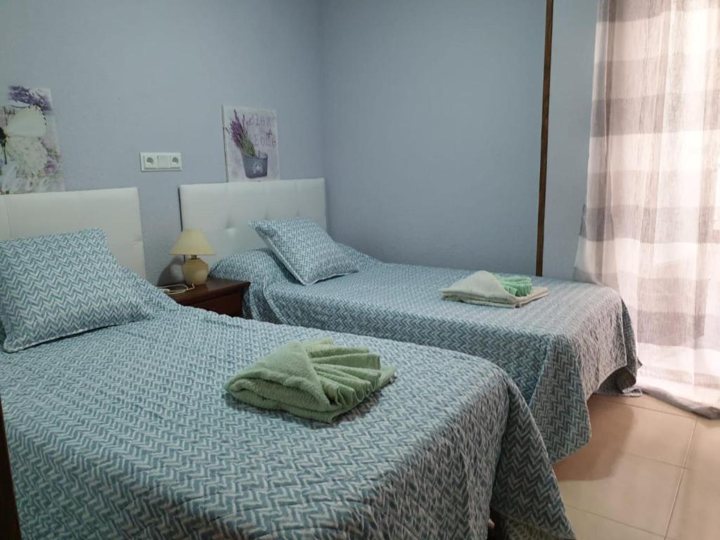 una camera con due letti con asciugamani di Apartamento Ángel en Palma a Benidorm