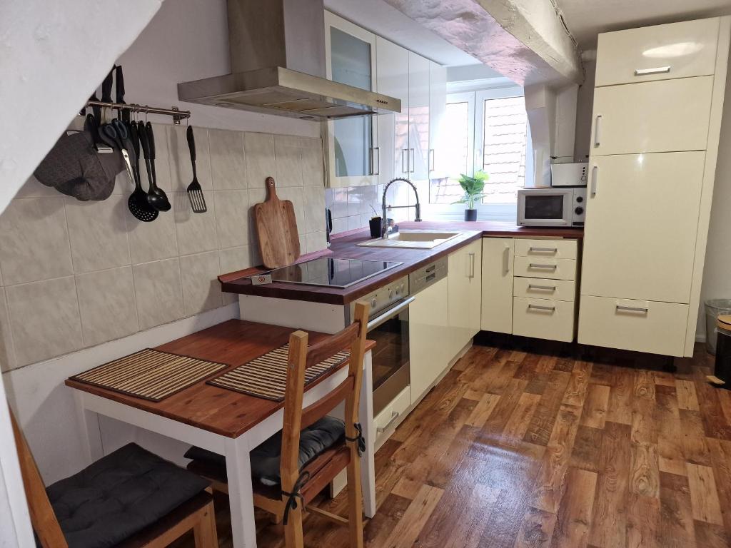 een kleine keuken met een houten tafel en een wastafel bij Tilly Apartment in Hannoversch Münden