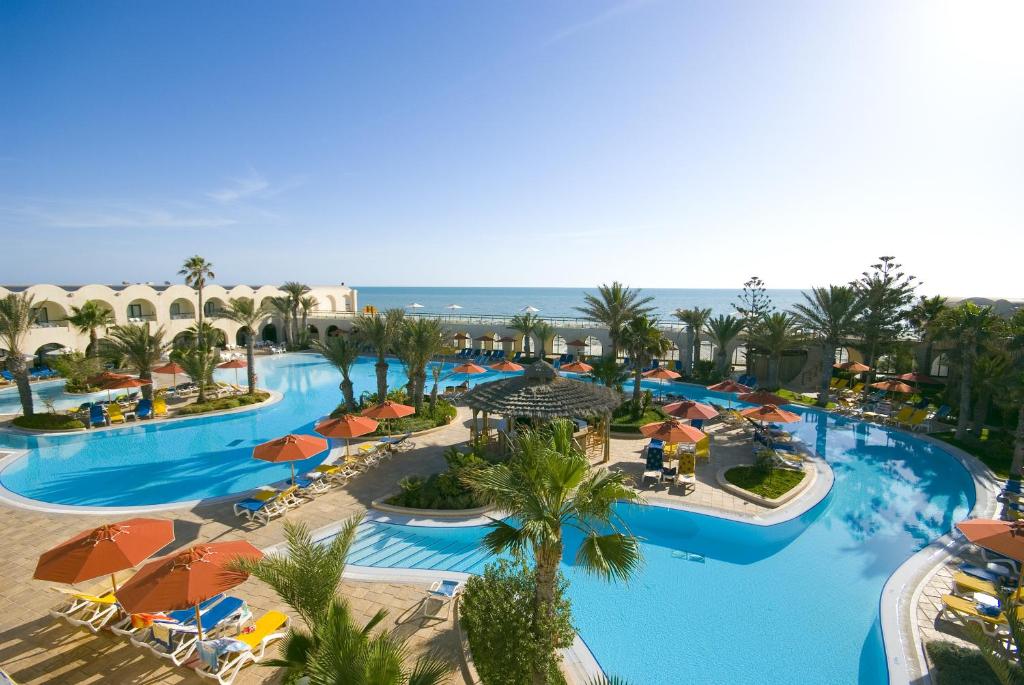 einen Luftblick auf einen Pool mit Sonnenschirmen des Resorts in der Unterkunft Sentido Djerba Beach in Midoun