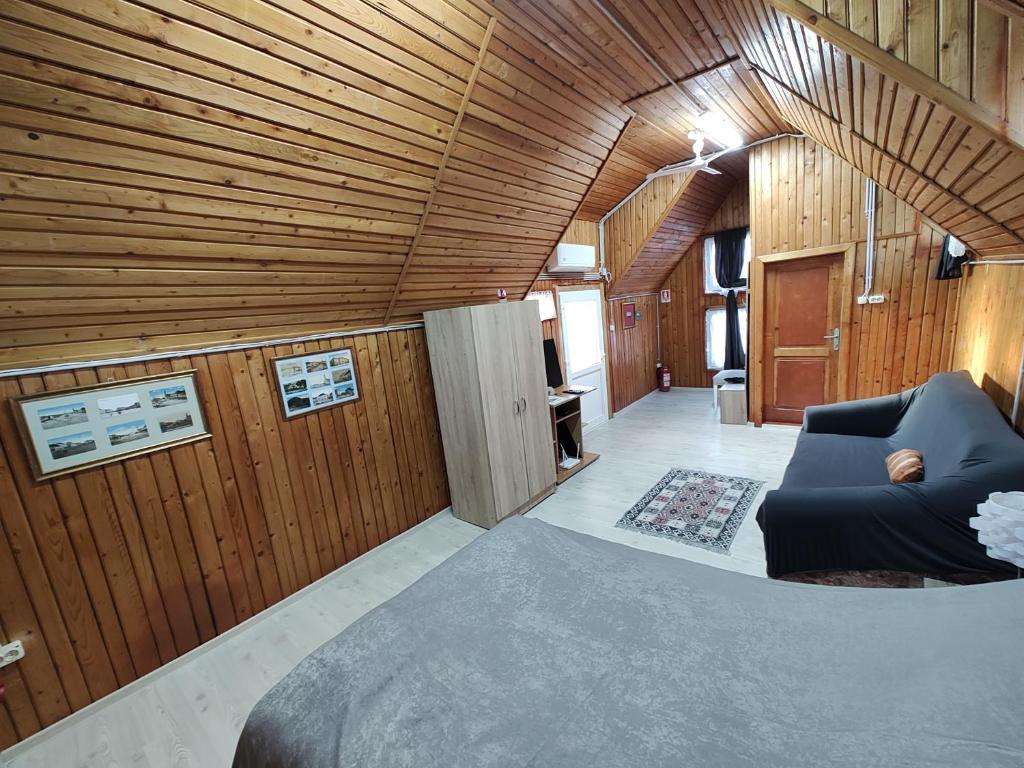 salon z kanapą i drewnianymi ścianami w obiekcie Casa cu Terase w mieście Syhot Marmaroski