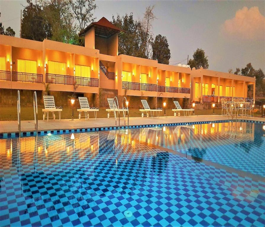 a swimming pool in front of a hotel at Kumbhal Exotica Resort Kumbhalgarh in Kumbhalgarh