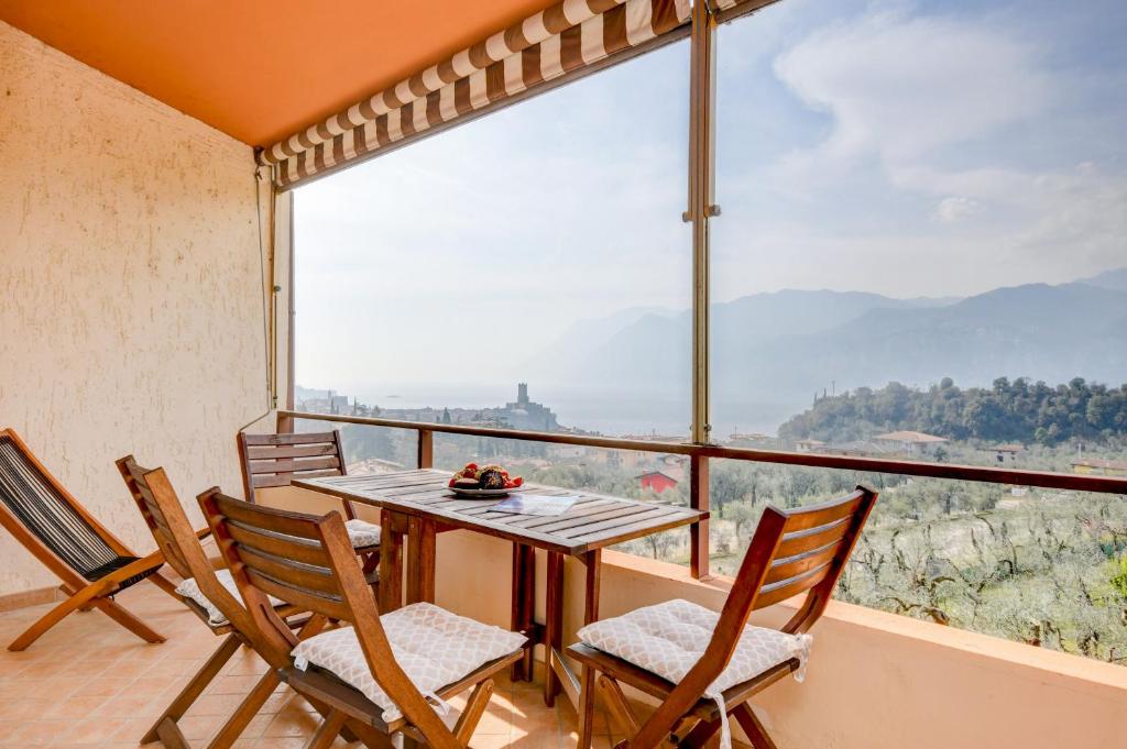 een eetkamer met een tafel en stoelen en een groot raam bij Residence Kormorano Malcesine Apt 52 in Malcesine