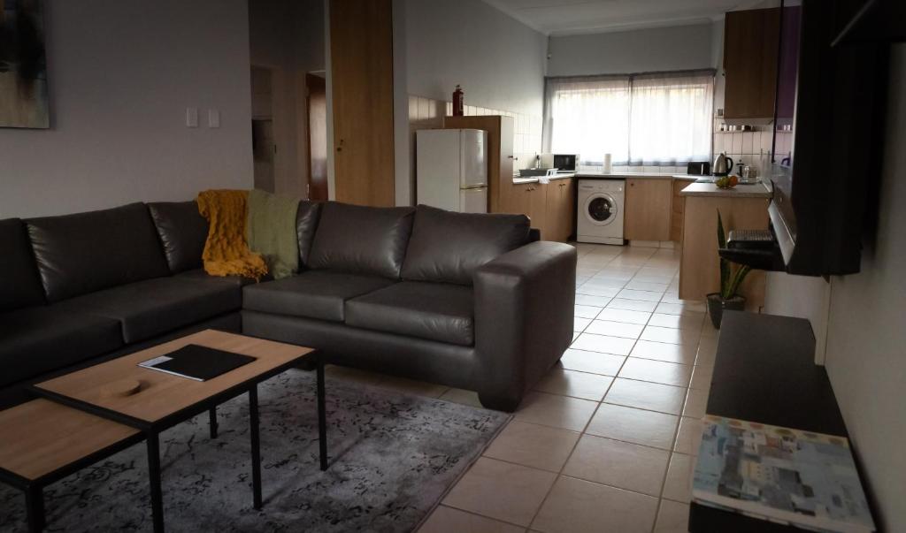 a living room with a couch and a table at VillaZek a modern 2 bedroom open- plan apartment with parking in Pretoria