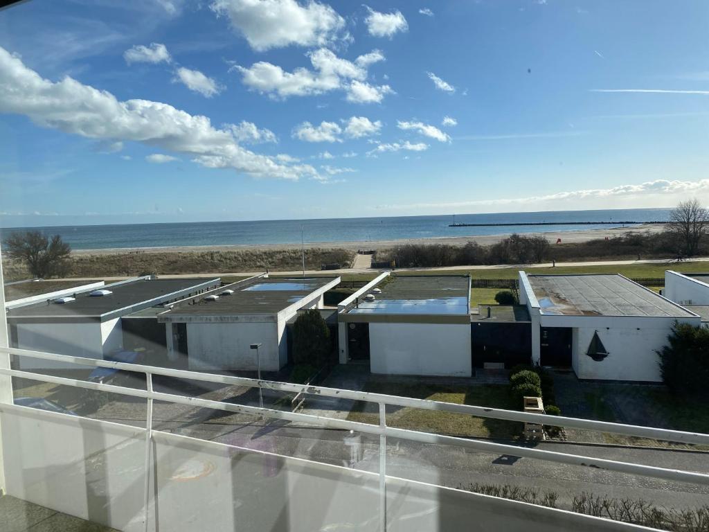 a view of a house with the ocean in the background at Längengrad 67 in Fehmarn