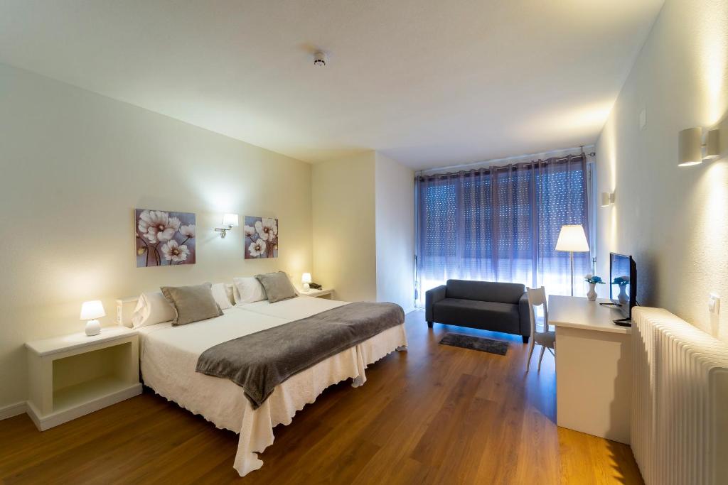 a bedroom with a bed and a chair and a window at Hotel La Mota by Punta25 Hotels Group in Medina del Campo