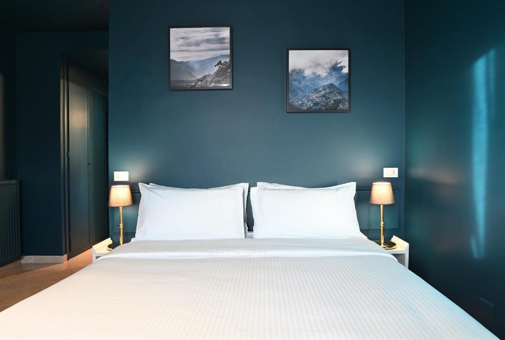a bedroom with a large white bed with three pictures on the wall at Il Ciocco Hotels in Barga